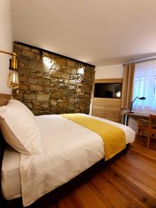 科佩尔Casa Isabella B&B的一间卧室设有一张带石墙的大床