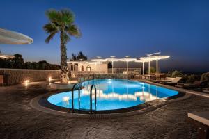 梅萨雷亚Marvarit Suites的棕榈树的游泳池