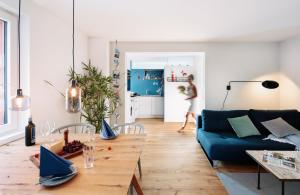 布雷根茨Rotes Haus Bregenz See Wohnung的客厅配有蓝色的沙发和桌子