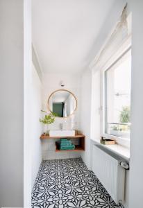 布雷根茨Rotes Haus Bregenz Wald Wohnung的浴室铺有黑白瓷砖地板,配有镜子