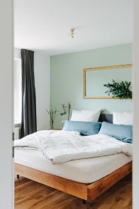 布雷根茨Rotes Haus Bregenz Wald Wohnung的卧室配有带蓝色枕头的大型白色床