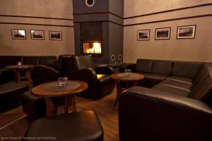 GratangenArctic Inn的餐厅配有沙发、桌子和壁炉