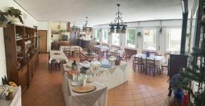 法纳诺hotel Bologna的一间大房间,餐厅内摆放着桌椅