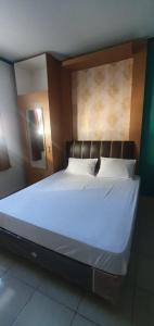 SungaidurianRumah Dempo Syariah的一间卧室配有一张带白色床单的大床