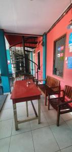 SungaidurianRumah Dempo Syariah的庭院设有2张长椅和红色的桌椅