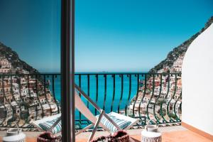 波西塔诺爱赛昂公寓式酒店的阳台配有椅子,享有海景。