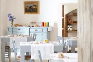 莱切Masseria Borgo Mortella的用餐室配有白色的桌子和白色的椅子