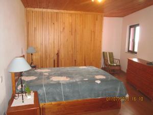 阿鲁卡Pêssego - AL的一间卧室设有一张床和木墙