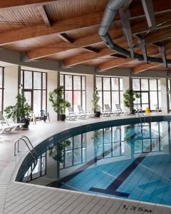 切佩拉雷博瑞卡酒店的一座大型游泳池,位于一座带窗户的建筑内