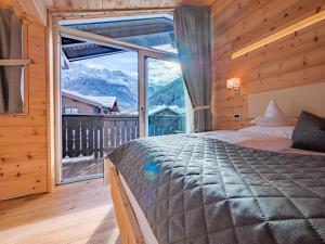 塞尔瓦迪加尔代纳山谷Chalet Elisabeth dolomites alpin & charme的一间卧室设有一张床和一个大窗户