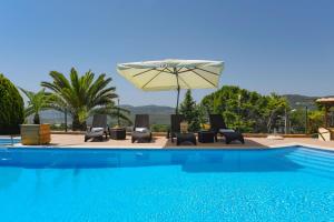 圣布拉什迪阿尔波特尔Hotel Rural Rocha da Gralheira的一个带躺椅和遮阳伞的游泳池
