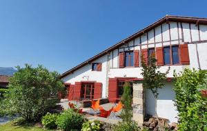 圣让-德吕兹La ferme d'Ika的前面有红色百叶窗和椅子的房子