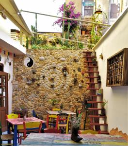 干尼亚Poco Loco Bed & Breakfast的一间设有石墙、桌子和椅子的客房