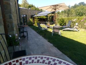 阿普里尔齐Boomerang Guest House的庭院里设有带椅子和遮阳伞的庭院。