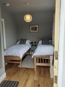 海伦斯堡Black Stair Cottage的一间卧室配有两张床和吊灯。