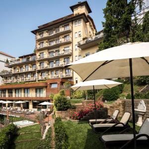 罗塔迪马尼亚米瑞蒙蒂度假村及Spa酒店的酒店前面设有椅子和遮阳伞