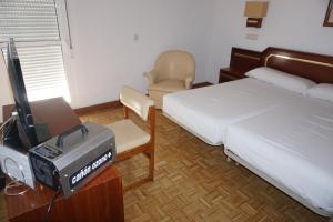 帕洛斯德拉夫龙特拉圣玛丽亚酒店的一间卧室配有一张床、一台电视和一把椅子