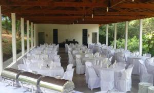 卡孔德Pousada Encanto da Mata - Ecológica的宴会厅配有白色的桌子和白色的椅子