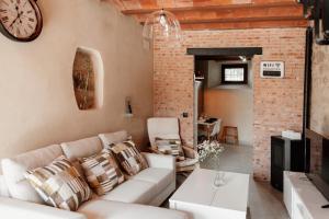 特鲁希略Casa Rural Turgalium的客厅配有沙发和墙上的时钟