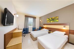 沙迦沙迦城市麦克斯酒店的酒店客房设有两张床和一台平面电视。