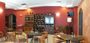兰达佐Hotel Scrivano的一间带桌椅和葡萄酒瓶的餐厅