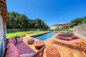 博尼法乔Villa du Couvent Version Maquis的一个带沙发和椅子的庭院和一个游泳池