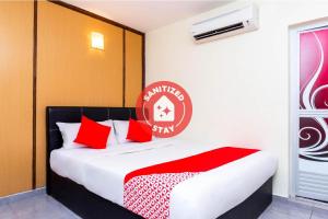 麻坡Super OYO 756 Muar City Hotel的一间卧室配有红色枕头的床