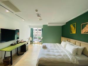 台中市台中丰禾行旅的一间卧室配有一张带绿色墙壁的床