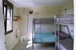 Pesquera de DueroALBERGUE HOSTING DUERO的宿舍间配有双层床和椅子。
