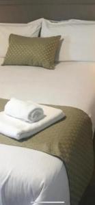 波塔姆纳Oak Lodge Portumna的两张带枕头和毛巾的白色床
