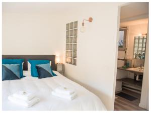 阿维尼翁Aventure Avignonnaise - ROOFTOP TERRASSE - INTRAMUROS - CITY CENTER的卧室配有白色床、蓝色枕头和水槽