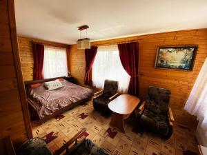 拉布卡Willa Światowid的一间卧室配有一张床、一张桌子和两把椅子