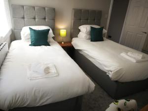 布里斯托Derby Den by Cliftonvalley Apartments的客房内的两张床和毛巾