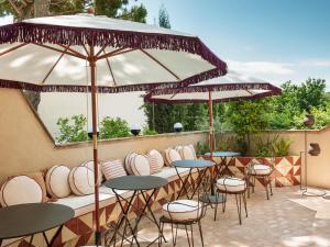 巴古尔La Bionda Hotel - Adults Only的庭院里摆放着一排桌椅和遮阳伞