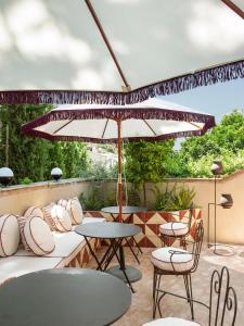 巴古尔La Bionda Hotel - Adults Only的一个带桌椅和遮阳伞的庭院
