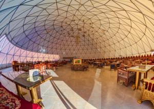 瓦迪拉姆艾沙记忆豪华帐篷的大房间设有大圆顶,配有桌椅