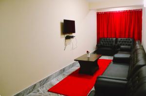 甘托克Bankhim Residency (Parking available)的客厅配有黑色皮革家具和红色窗帘