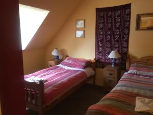 博特夫加滕Fraoch Lodge的一间卧室设有两张带粉色床单的床和窗户。