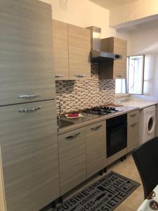 普罗斯西托角Casa Ezio 1 PT的厨房配有木制橱柜和炉灶烤箱。