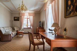 敖德萨莫扎特酒店的客厅配有书桌和沙发。