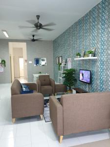 马六甲Teratak Mini Pool Homestay Melaka的客厅配有两张沙发和一台电视机