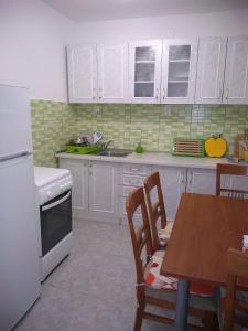 博格莫耶House Filip的厨房配有白色橱柜和桌椅