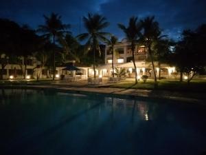 马林迪蓝马林体育度假酒店的房屋前游泳池的夜景