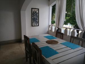 马林迪蓝马林体育度假酒店的用餐室配有带蓝色餐巾的桌子