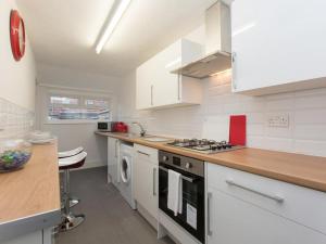 克鲁Townhouse @ 166 Ruskin Road Crewe的厨房配有白色橱柜和炉灶烤箱。