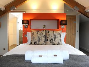 Gosforth1692 Wasdale的一间卧室配有一张带橙色床头板的大床