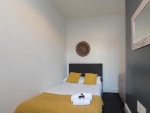 克鲁Townhouse @ 83 Edleston Road Crewe的一间卧室配有一张带黄色枕头的床