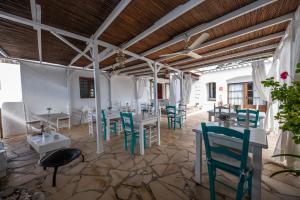 圣塔格鲁迪斯坎科斯米普拉茨农家乐的用餐室配有白色的桌子和蓝色的椅子