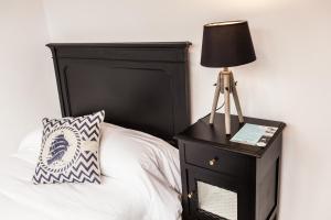 塞洛里奥The Old Seaman Bed & Breakfast的一张带黑色床头板的床和床头灯