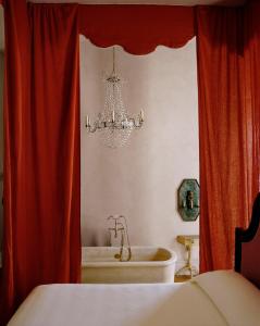 新奥尔良Hotel Peter and Paul的一间卧室配有吊灯、一个浴缸和一张床